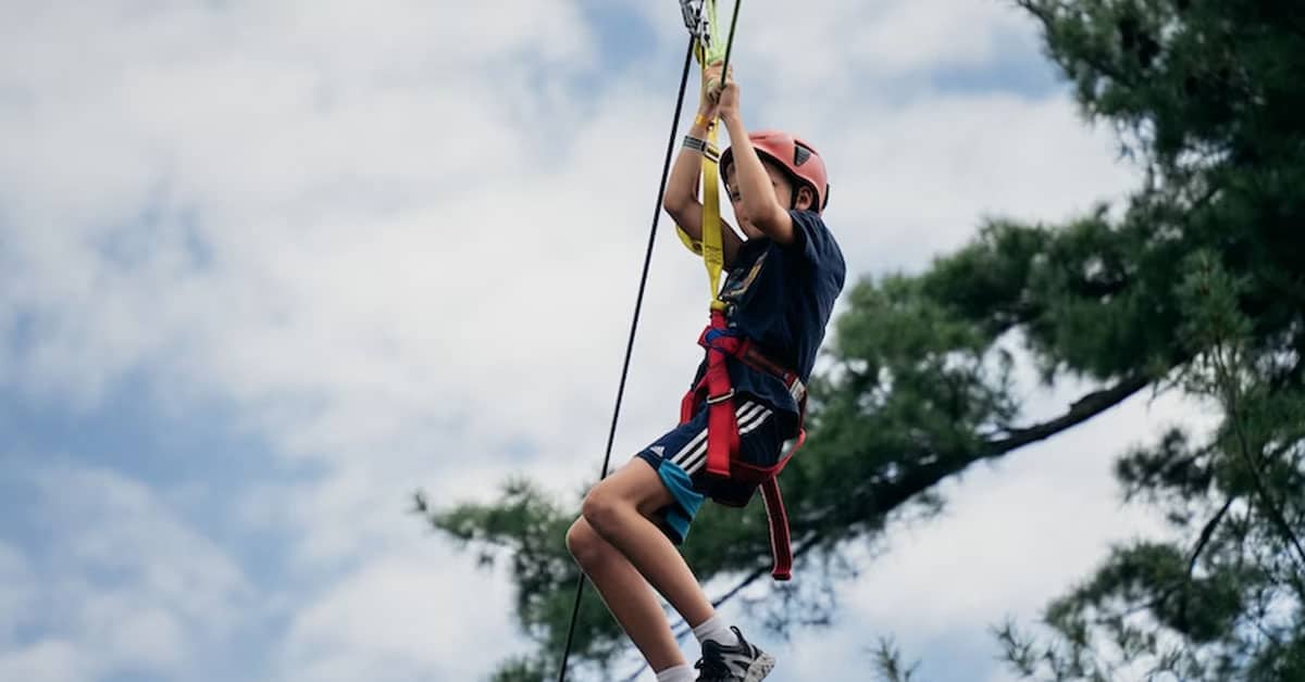 A kid swinging on a zip line.
