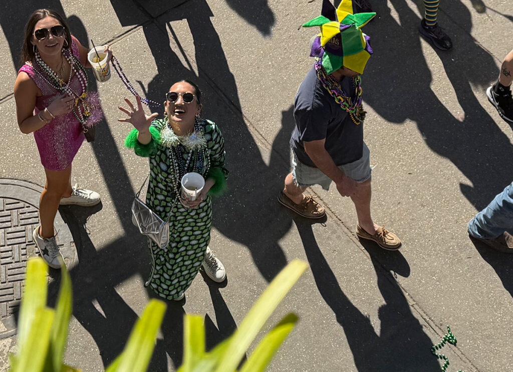 Lady catching beads from balcony