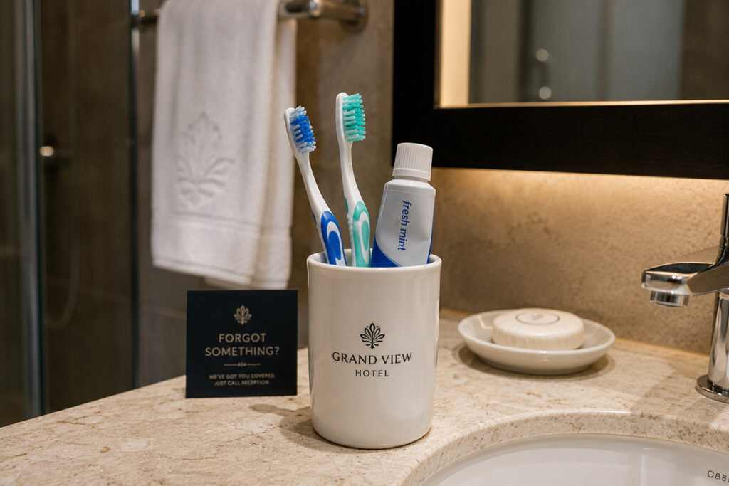 toothbrushes in a cup in a hotel bathroom